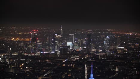 Porta-Nuova-of-Milan-at-night-with-glowing-lights,-aerial-view