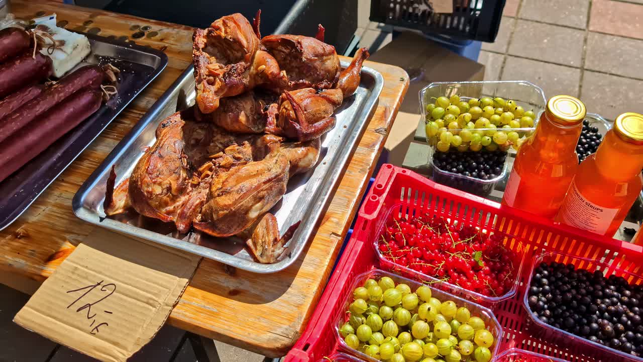 Fresh fruits, juices, and roasted meat at outdoor market display
