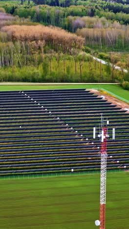 vertical view of solar power for telecommunication tower in countryside fields.