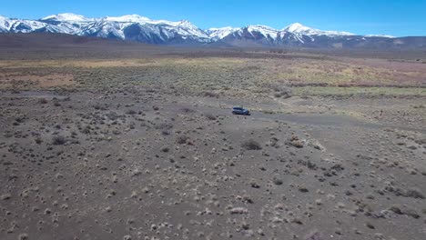 antena encima de un 4wd viajando por un camino de tierra en el desierto de mojave con las montañas de sierra nevada distantes
