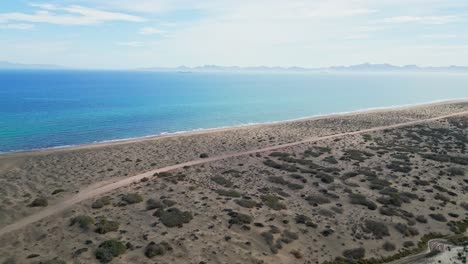 coastal desert in el mogote, la paz with calm blue sea and dry brush, aerial view