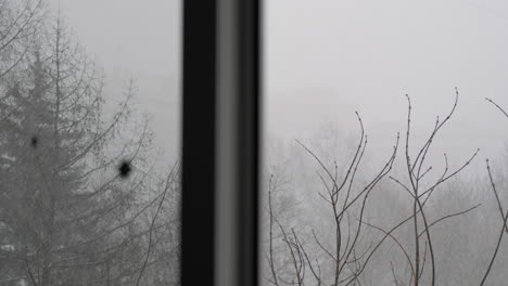 heavy snowfall outside the window looking through the window