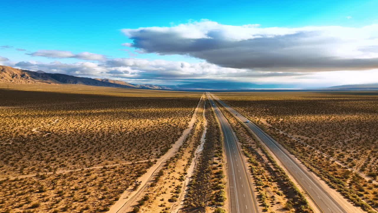 Flying above the highways crossing the deserted land. Numerous little bushes covering the dry landscape. Aerial view.