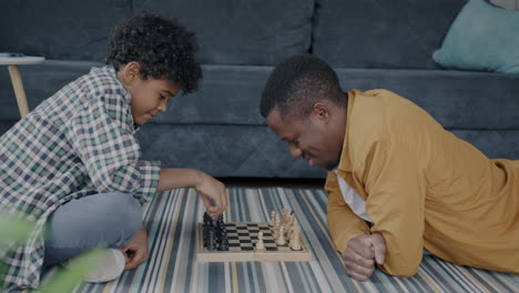 padre e hijo jugando al ajedrez en casa