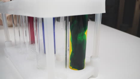 mixing dark green and yellow paints in test tube on rack