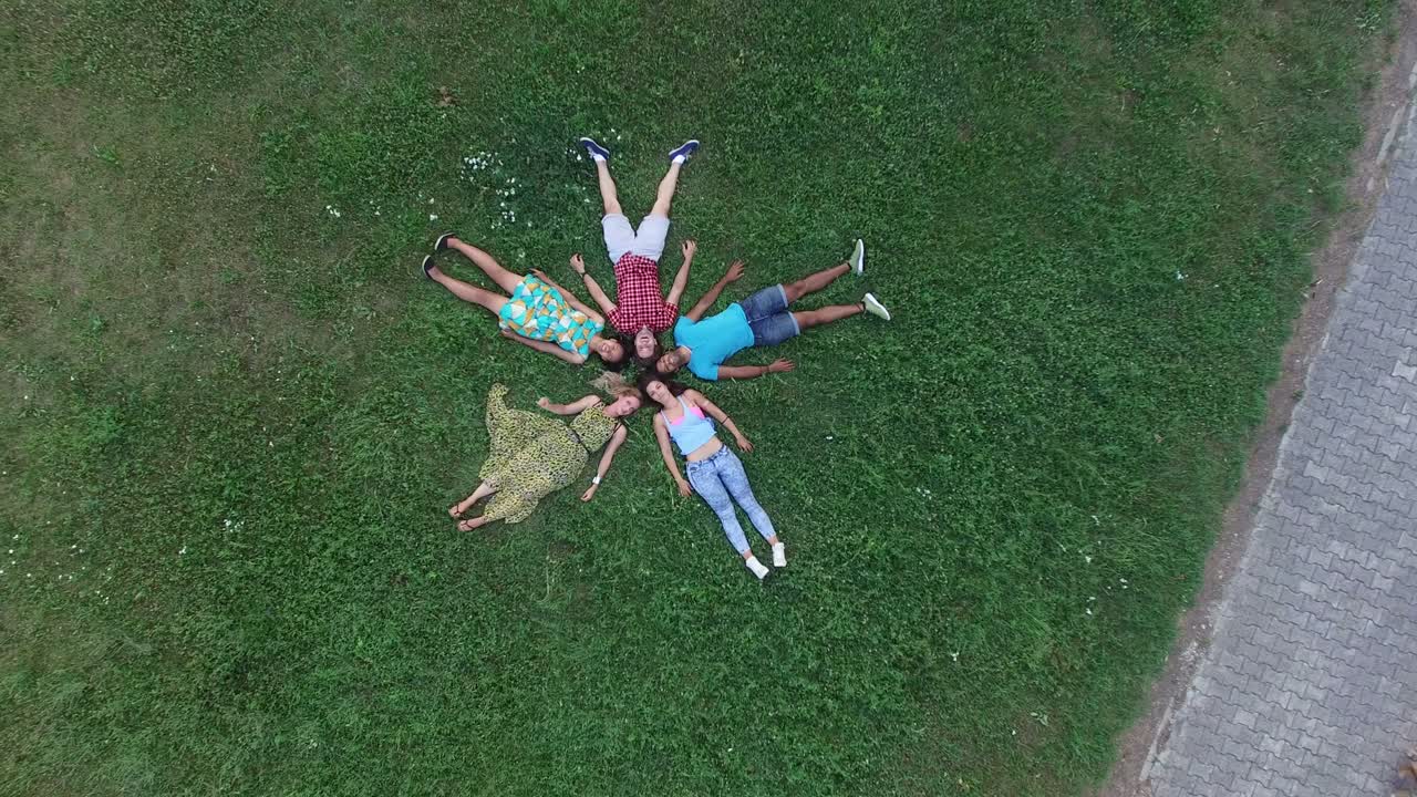 잔디 에 누워 있는 별 모양 을 형성 하는 친구 들 의 위 에서의 모습