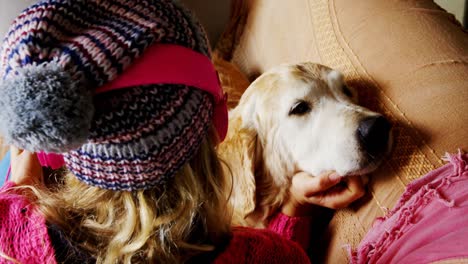 mujer acariciando a su perro en el sofá en casa 4k