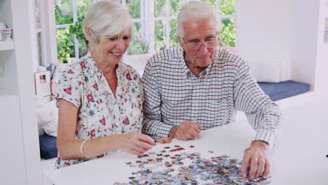 Älteres-Paar-Macht-Zu-Hause-Gemeinsam-Puzzle
