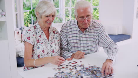 senior couple doing jigsaw puzzle together at home