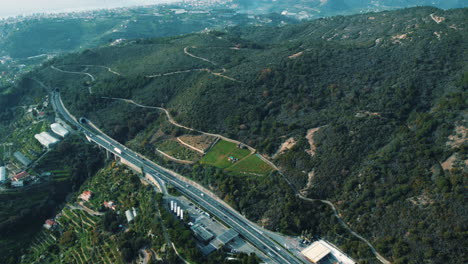 aerial view of a mountain highway with tunnels and a service area