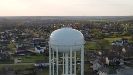 aerial vertigo shot of water tower, revealing suburban neighborhood in the background