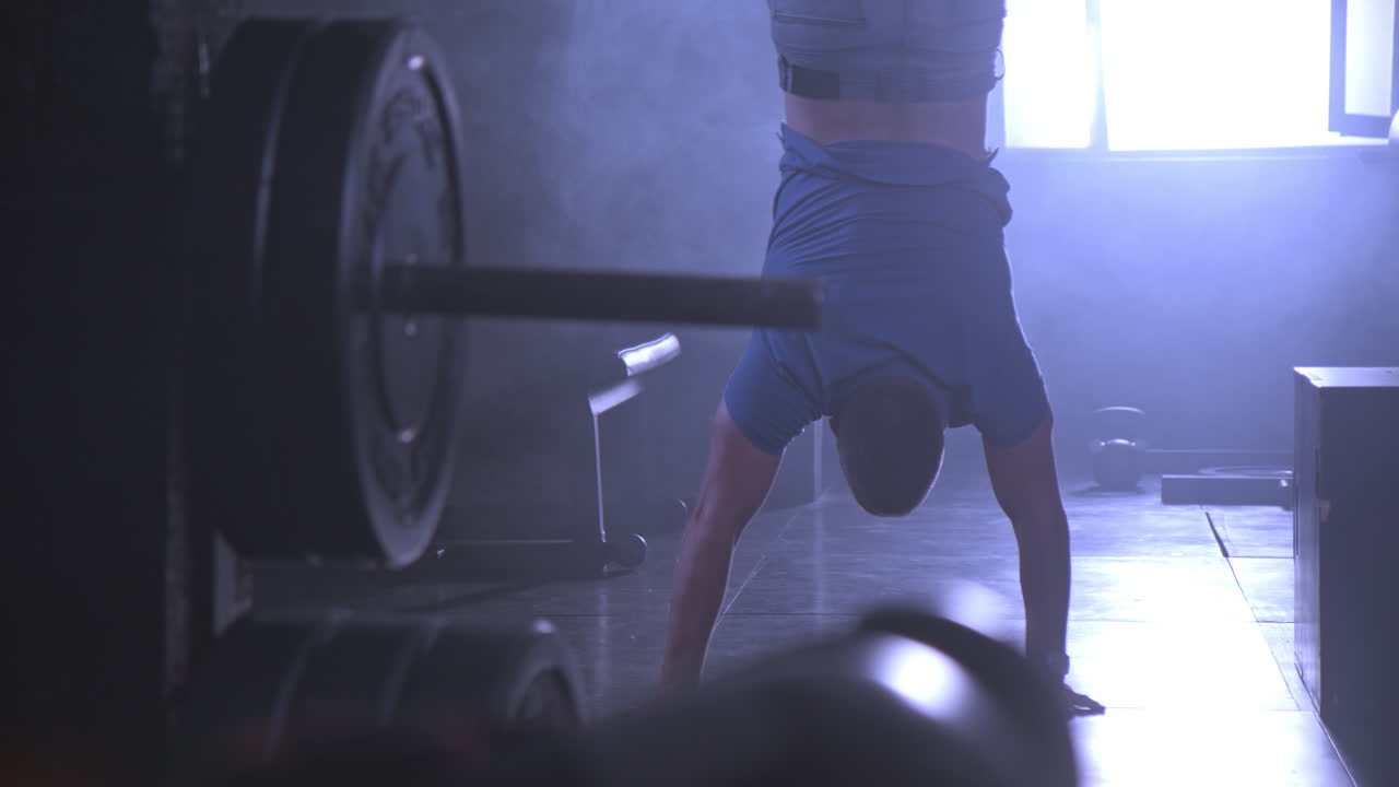 Man doing handstand in gym