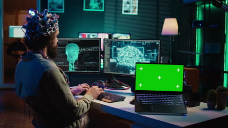 un neurocientífico sube el cerebro al ciberespacio usando una computadora portátil de pantalla verde.