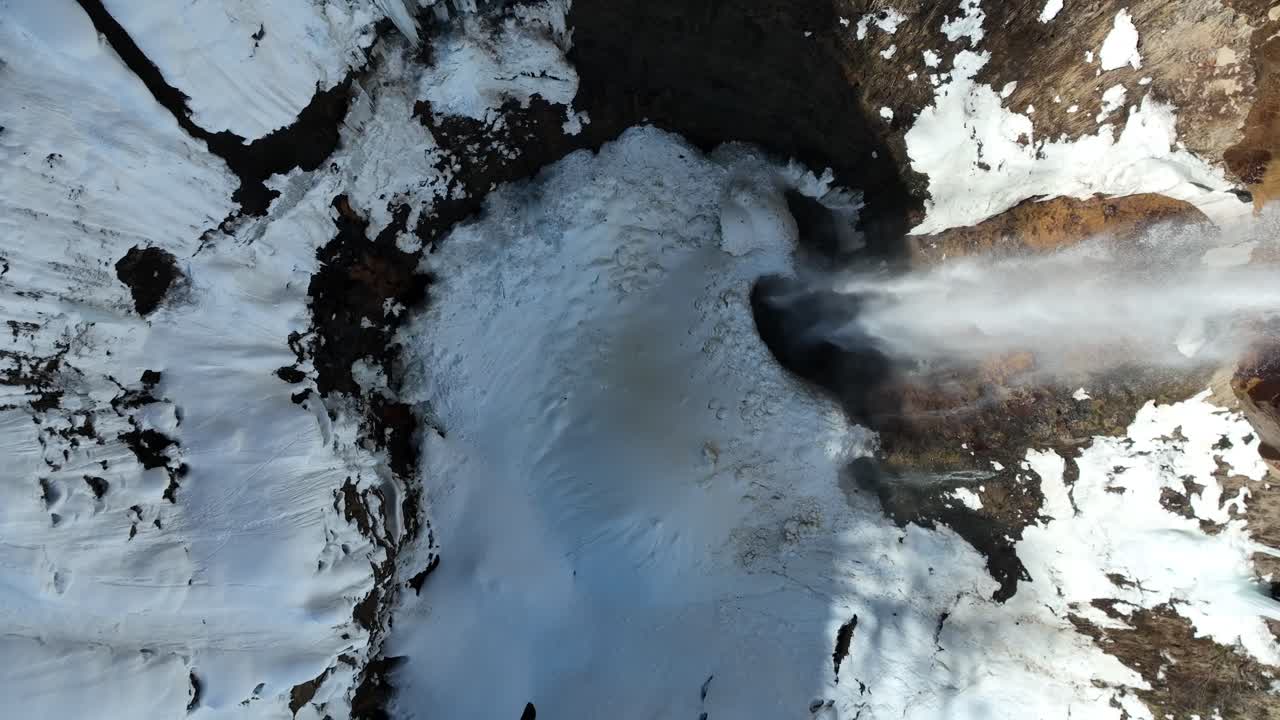 fotografía de arriba hacia abajo de la cascada desde el derretimiento de la nieve, el avión no tripulado subiendo revelando el tamaño de la cascade