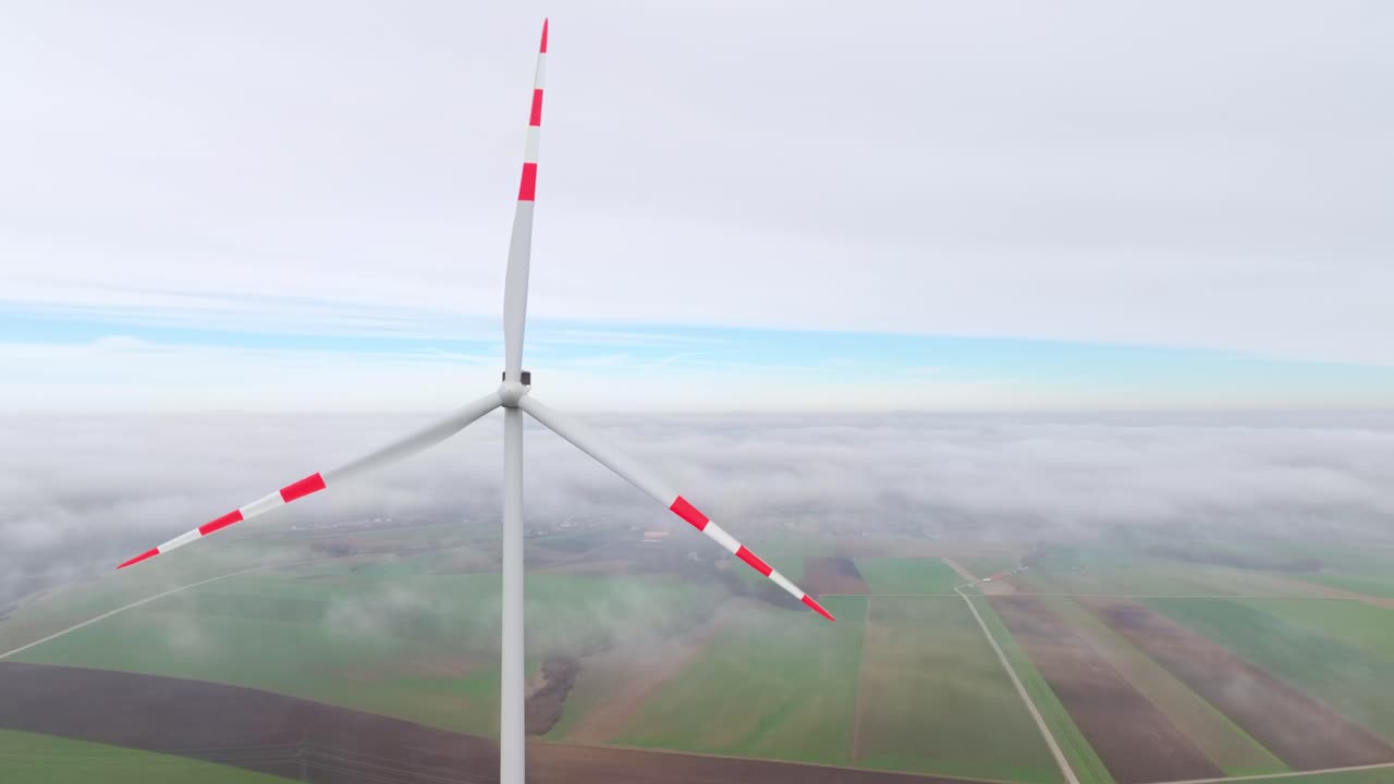 안개가 가득한 시골  위를 돌고 있는 풍력 터빈 블레이드