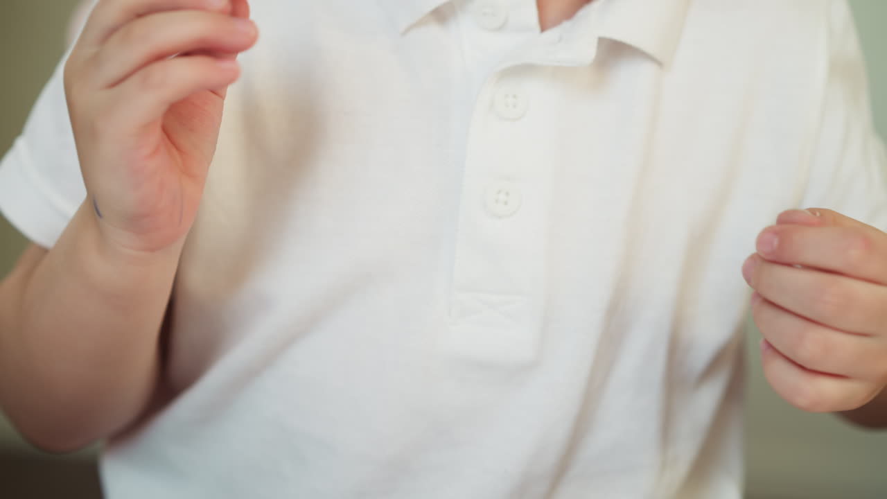 작은 소년은 파란 마커를 열고 책상에서 롤러를 가져갑니다.