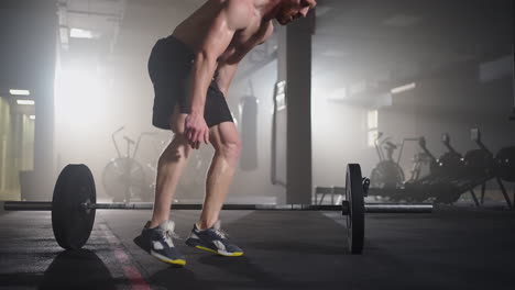 fitness man doing burpee workout at gym. medium shot of young man doing push ups and jump exercise in slow motion. sport concept