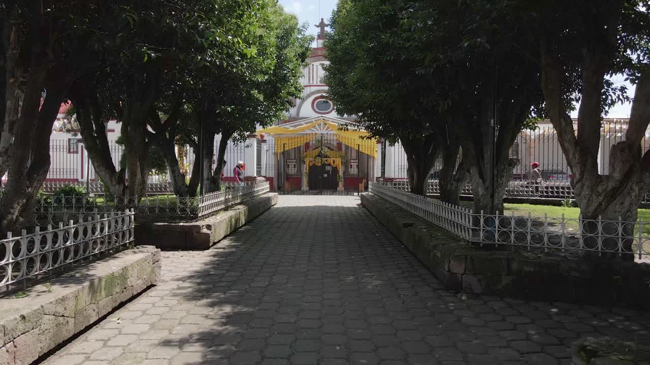 멕시코 알몰로야에 있는 호기심 많은 시선이 있는 오래된 석조 교회 입구를 향한 공중 전망