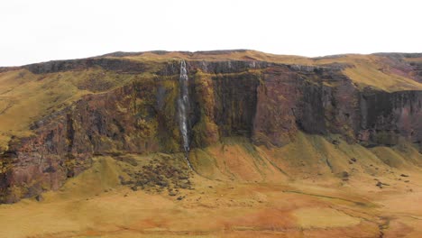 Riesiger-Bergrücken-Mit-Drífandi-Wasserfall-über-Nordischem-Grasland