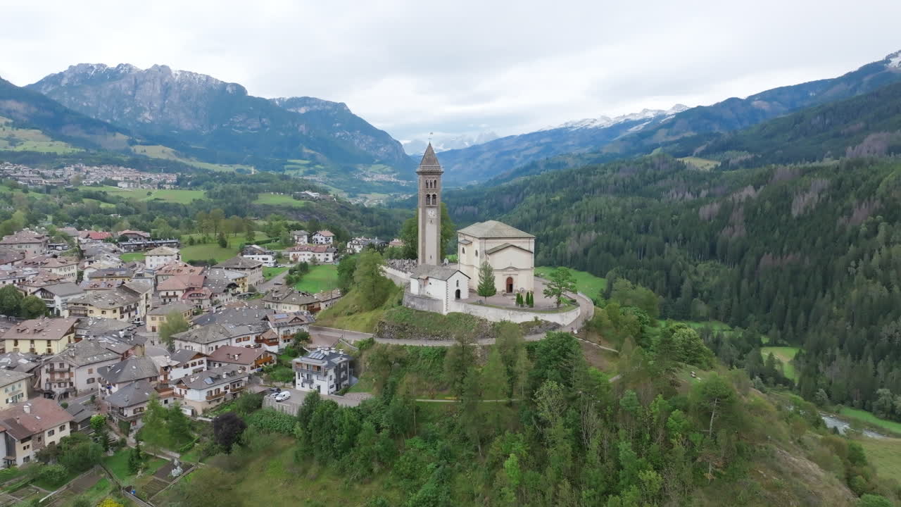 Aerial footage of the town Castello-Molina di Fiemme in Italy slowly moving towards the Chiesa di San Giorgio Church.