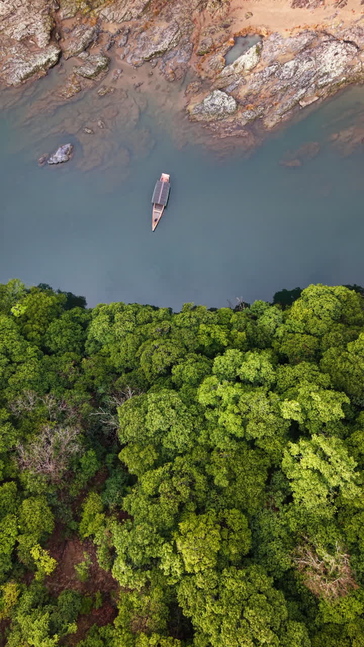 Aerial drone view of a boat moving on the Katsura River in Arashiyama, Japan in daylight