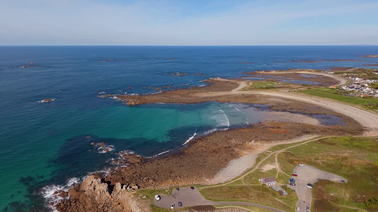 Guernsey Channel Islands high drone footage of bays with crystal clear sea gentle waves and rocky outcrops on sunny day