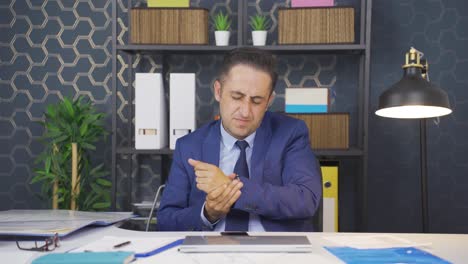 un hombre de negocios cansado con dolor en las muñecas.