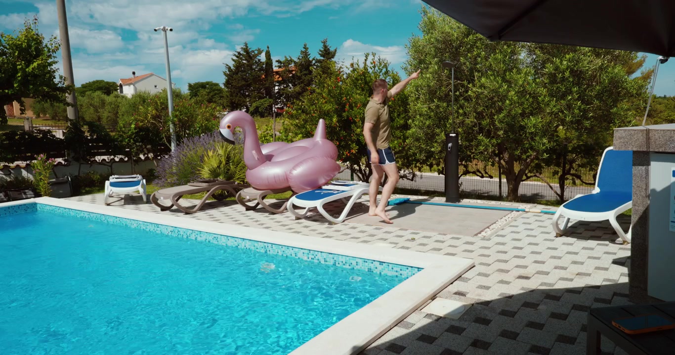 En mand demonstrerer og forklarer vigtigheden af at bruse sig, før man går i swimmingpoolen. Fokus på hygiejneregler, sikkerhed og korrekt adfærd ved et resort-poolområde.