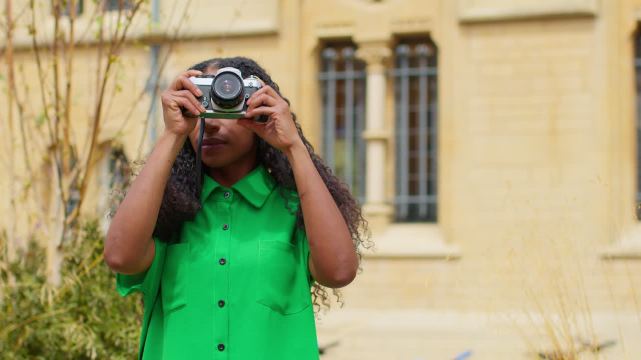 mulher turista com câmera de férias em oxford, reino unido, explorando a cidade, caminhando pela broad street, tirando fotos.