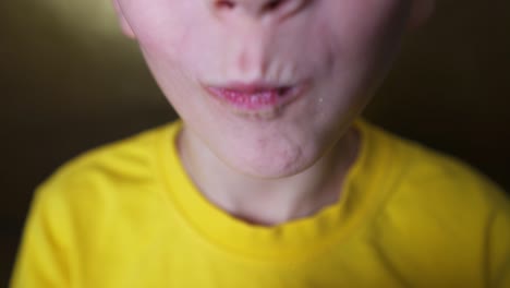 niño feliz comiendo una rosquilla de chocolate. niño comiendo comida chatarra. rubio disfruta de dulces.