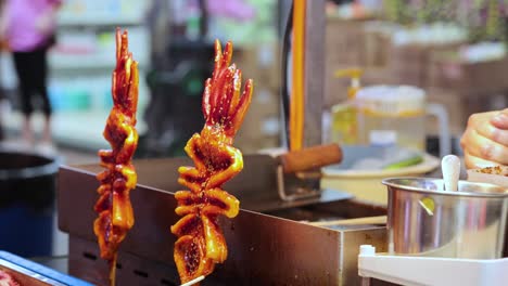 vendor prepares grilled squid skewers in hong kong