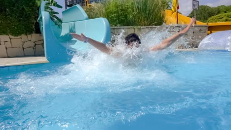 Abstieg-Von-Der-Wasserrutsche-Im-Ferien-Aquapark.-Zeitlupe-Auf-Einer-Wasserrutsche-Im-Familienurlaub:-Eine-Frau-Im-Bikini-Steigt-Von-Der-Rutsche-In-Ein-Becken-Mit-Blauem-Wasser,-Aus-Dem-Wassertropfen-Spritzen.