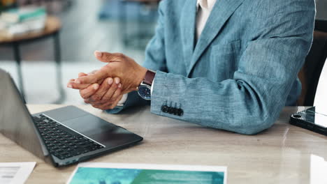 man in suit at desk with laptop and documents