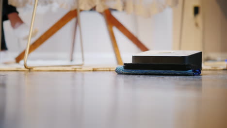 pequeño robot pule el piso de madera dura