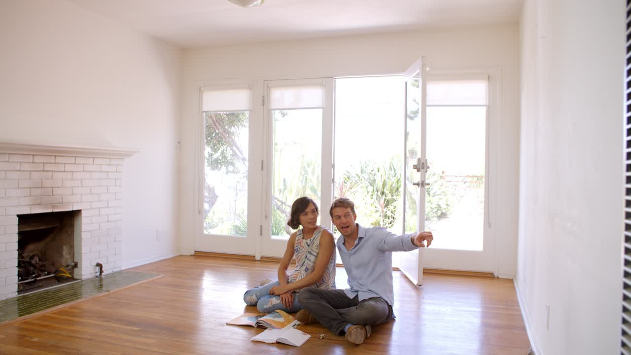 pareja emocionada planeando la decoración de su nuevo hogar