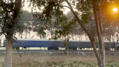 indian railway freight trail passing by during sunset in the countryside