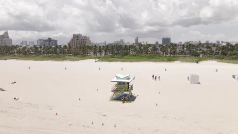 Aerial-flight-over-lifeguard-hut-toward-buildings-of-South-Beach-Miami