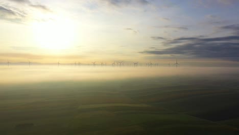 Wind-Turbines-In-Clouds-Against-Bright-Sun-In-The-Sky-At-Sunset