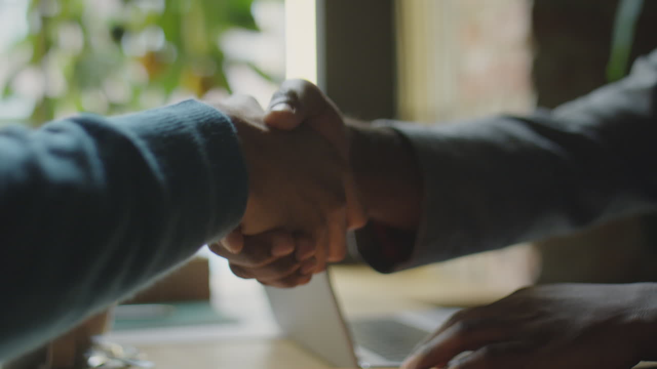 Handshake of Two Businessmen in Cafe