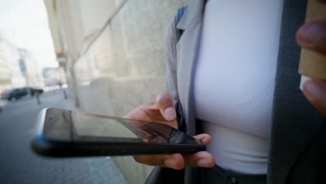 businesswoman using smartphone on city street