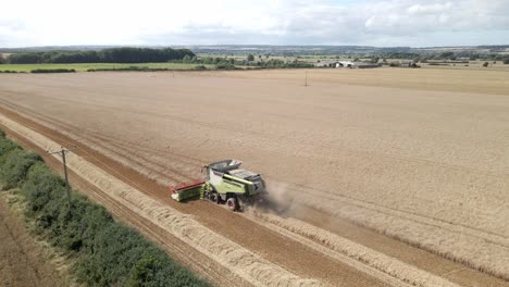 aerial footage of a combine harvester harvesting a wheat crop