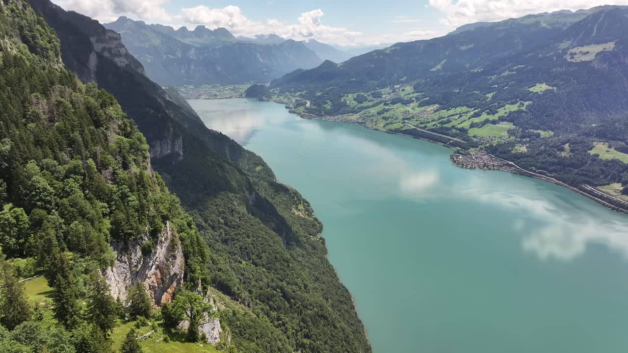 Aerial view of Walensee with steep forested cliffs and alpine villages in the distance, Switzerland