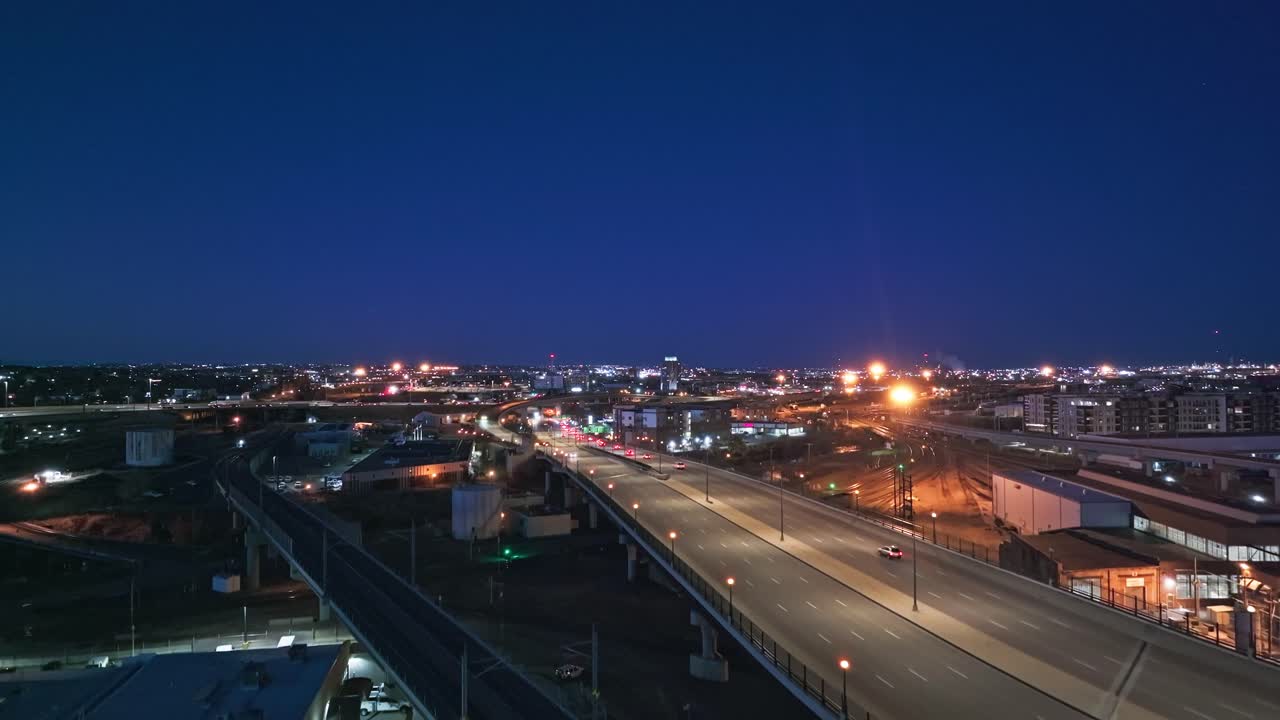 Aerial view of Coors Field at twilight, surrounded by city lights, highlighting the stadium architecture