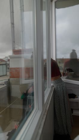 woman drying laundry on balcony