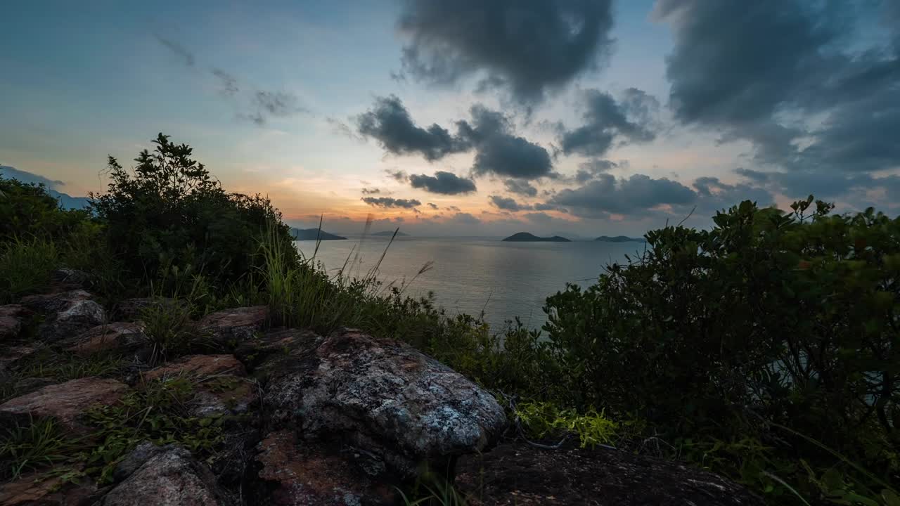 dramático relajante amanecer rojo cielo nublado sobre la ladera de la isla de lantau paisaje costero del océano de hong kong