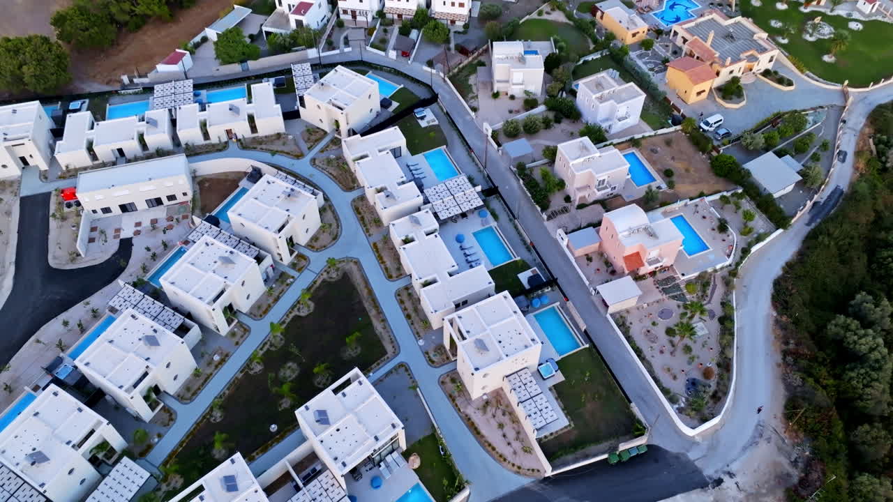 Aerial tilt shot backwards over a holiday resort village, dusk in Rhodes, Greece