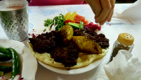 Squeezing-lemon-juice-on-a-grill-plate-of-traditional-Middle-Eastern-cuisine