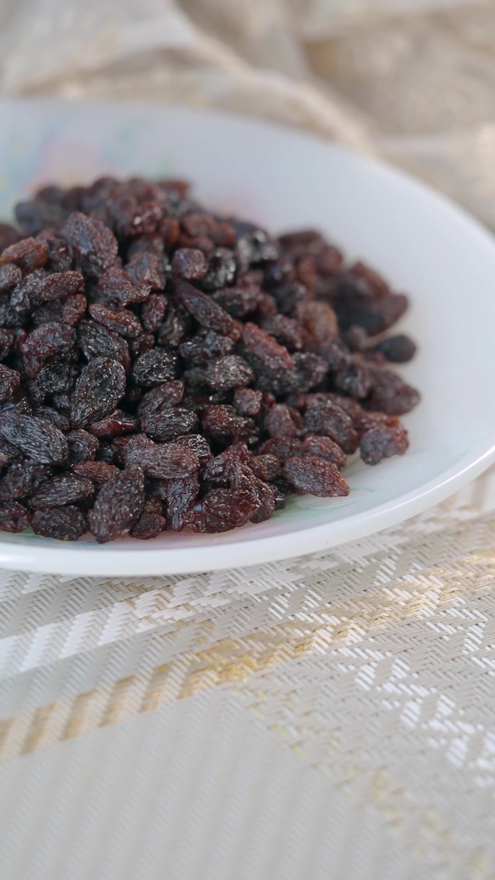 Gros plan d'un tas de raisins secs sur une assiette blanche