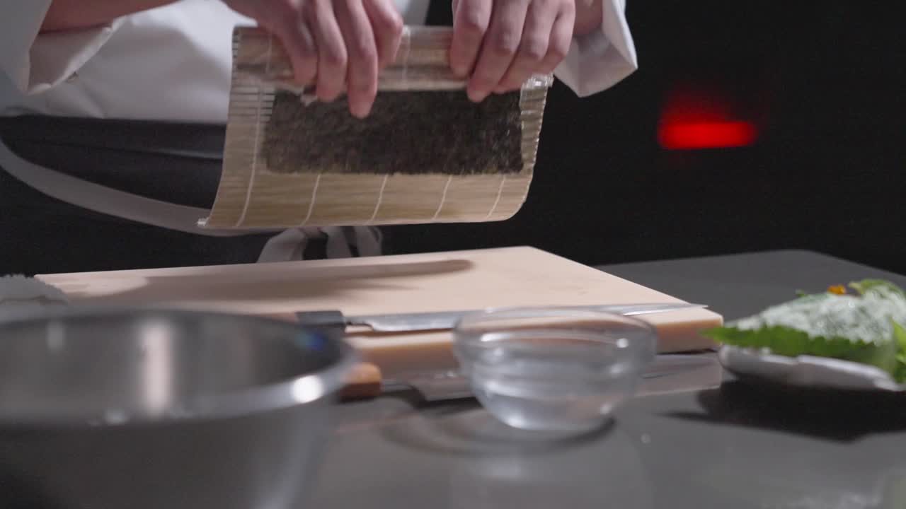 A static shot captures sushi rice being flipped, showcasing precision and technique in sushi preparation. Perfect for culinary, sushi-making, and professional kitchen content.