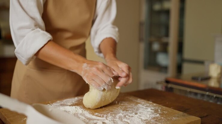 Woman Kneading Dough for Baking Bread